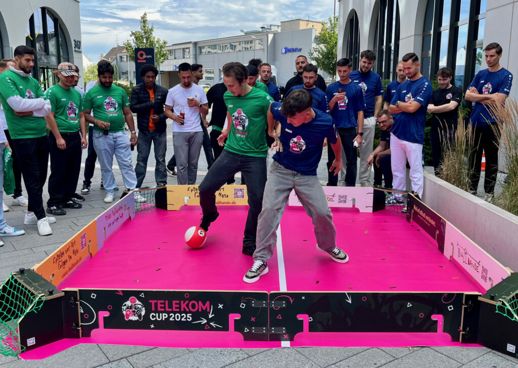 Jungs kämpfen um den Ball in dem mobilen Spielfeld der Ballbande auf dem Telekom Cup 2025