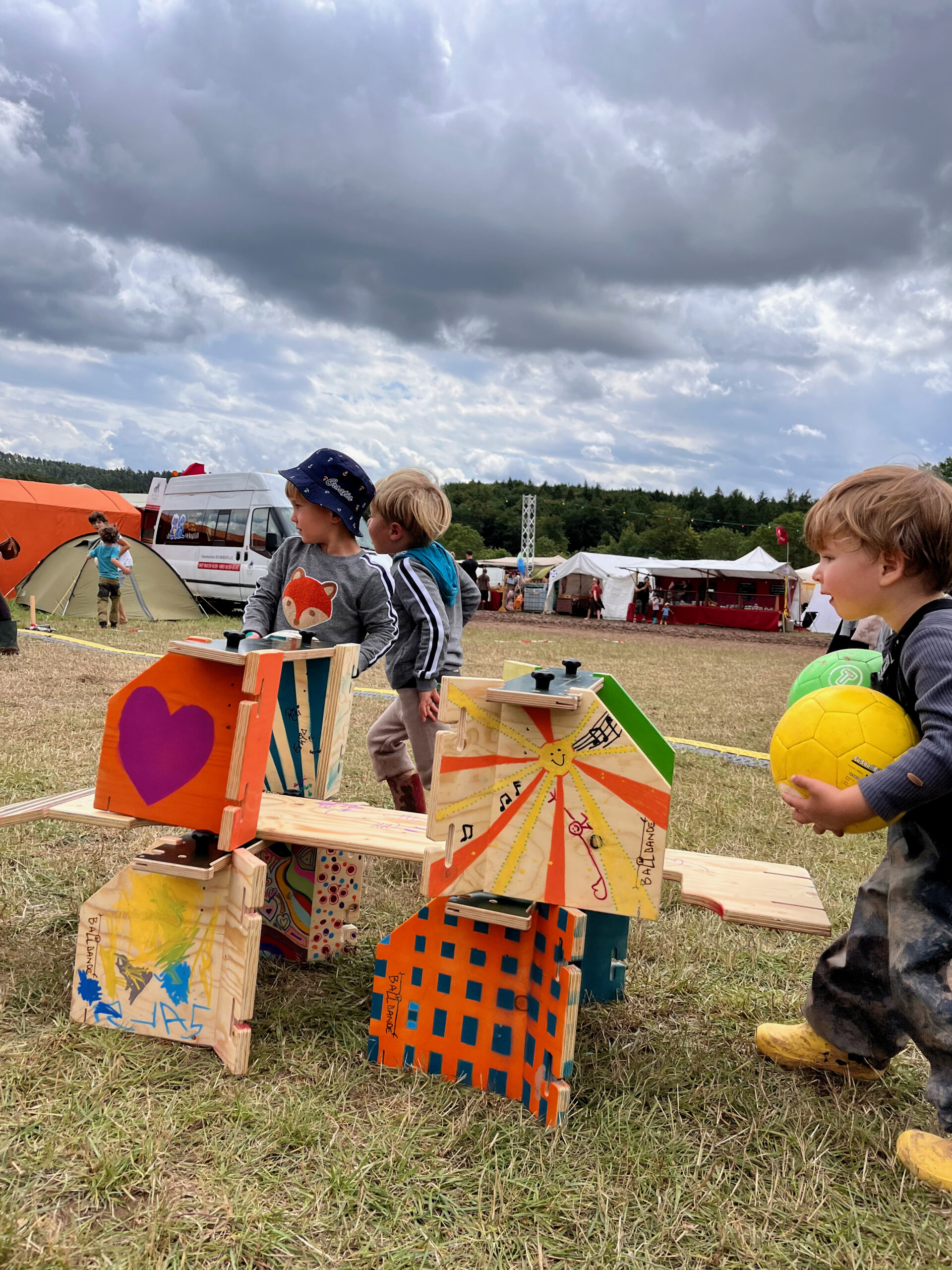 Kinder haben die Tore und Banden so aufgebaut dass eine Ballbahn entstanden ist und sie lassen die Bälle darauf runterrollen
