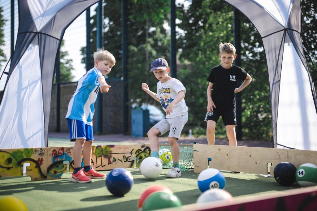 Kinder spielen Ballbande auf einem Event